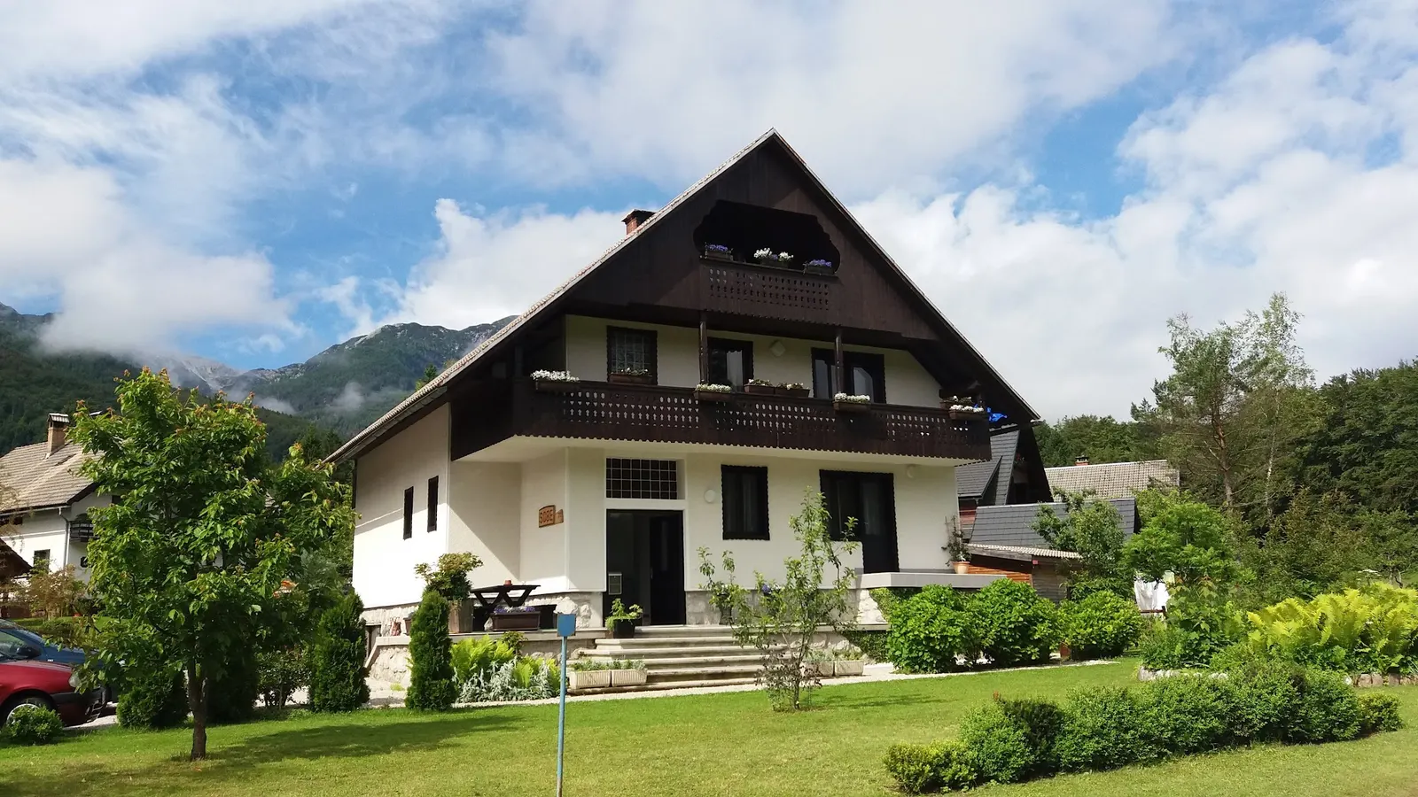 Bela hiša z lesenimi balkoni in vrtom v Ribčevem Lazu